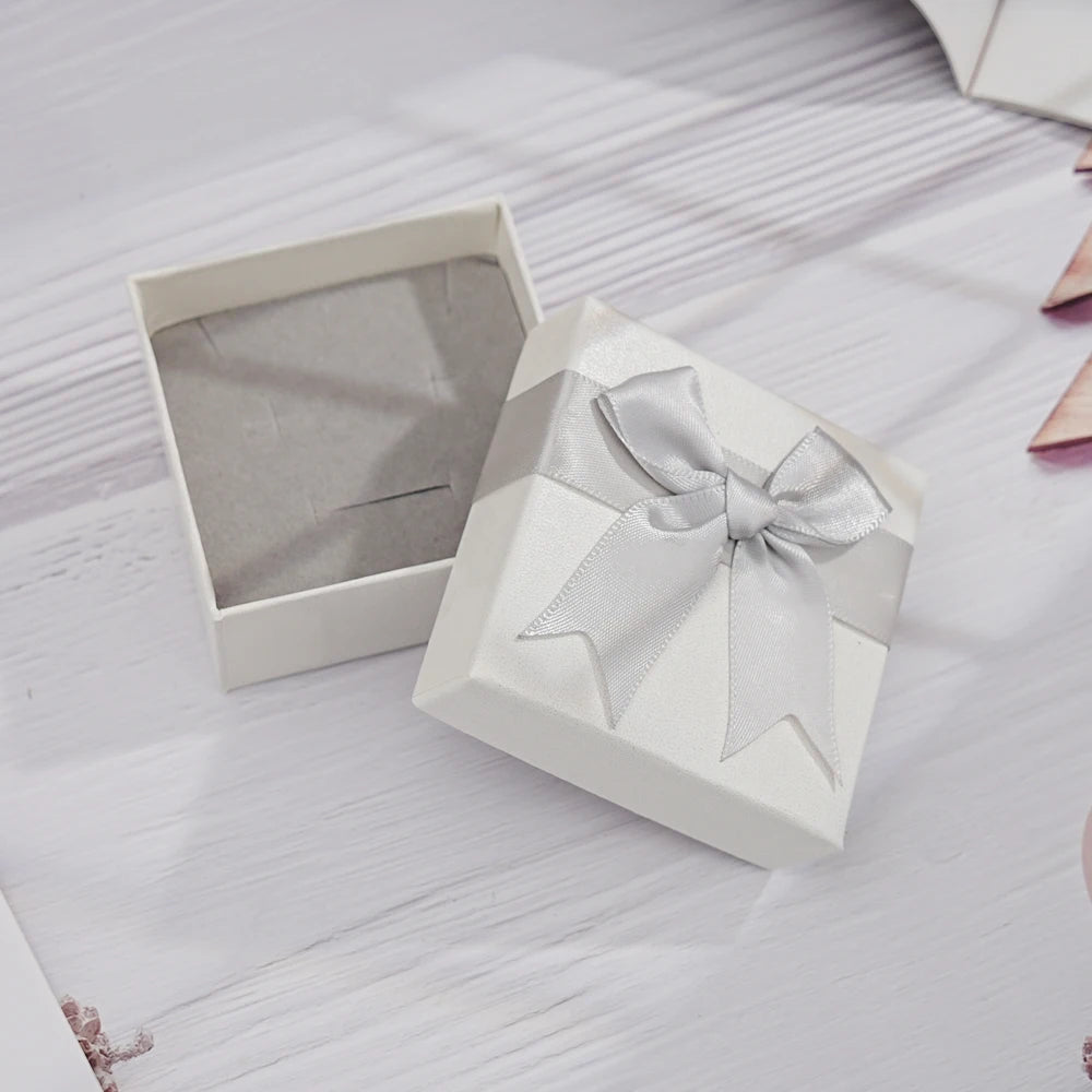 White gift box with a bow on a textured surface