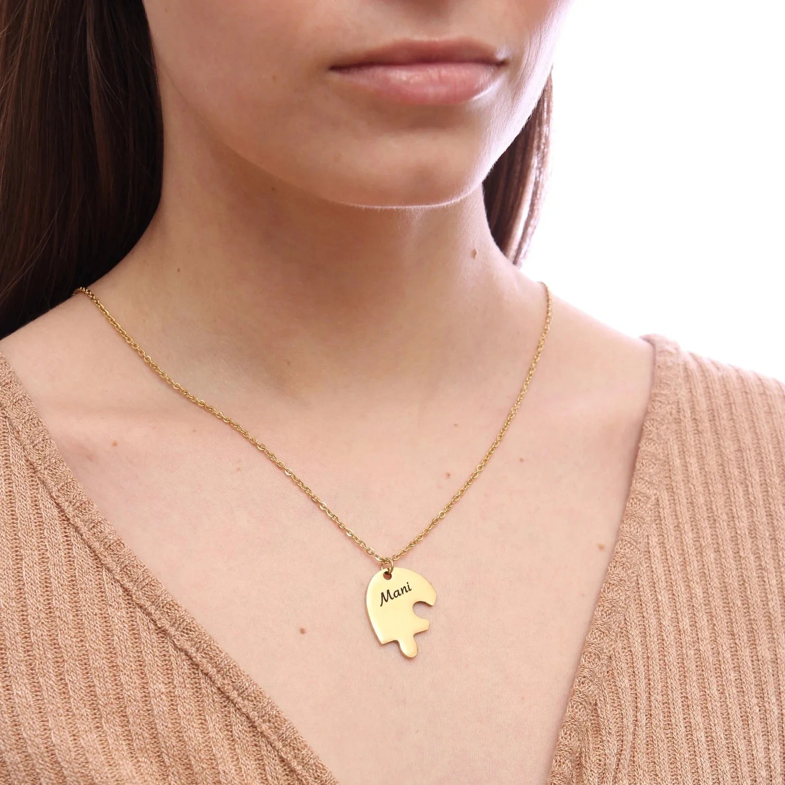 Gold engraved heart necklace worn by woman